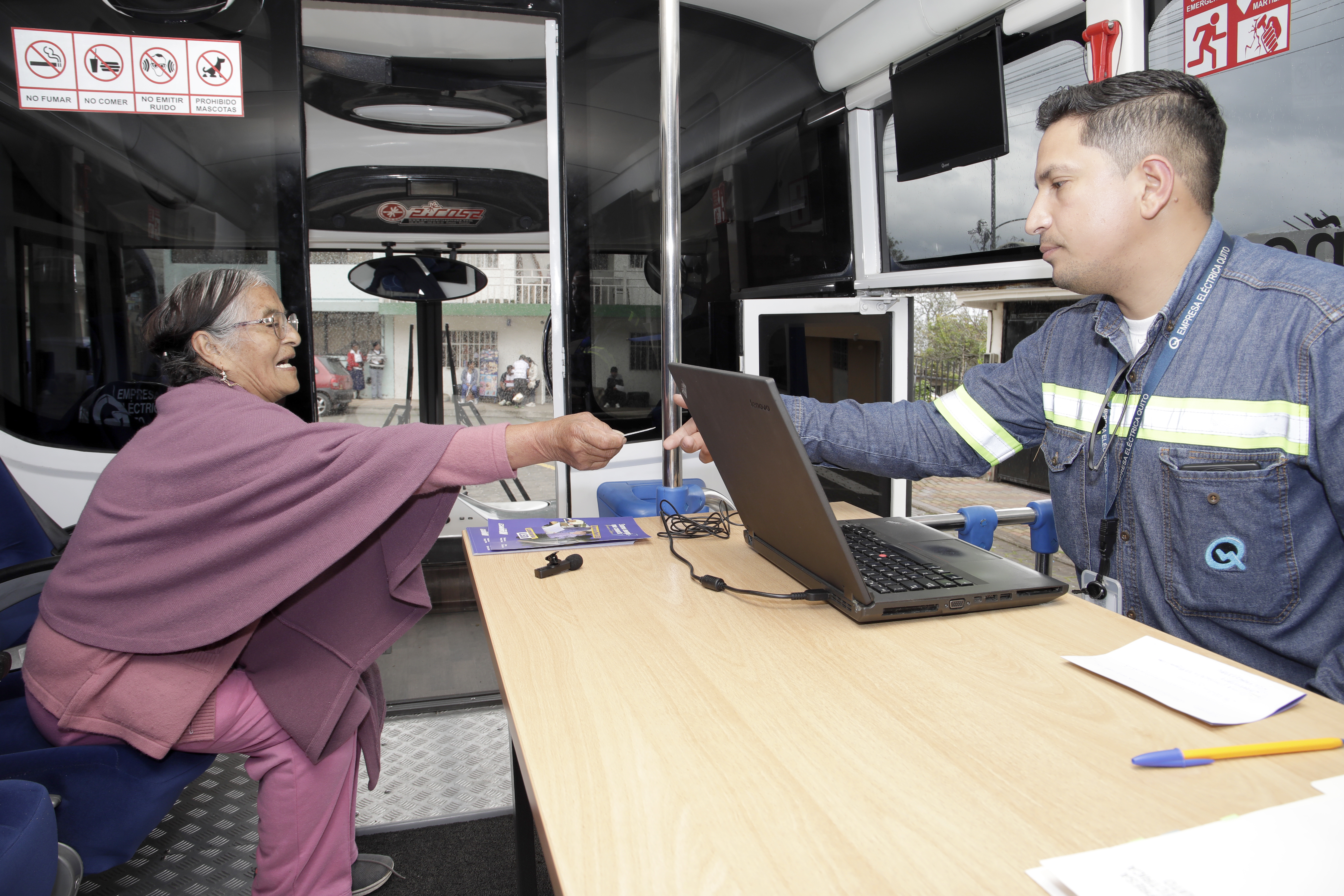 Cliente de la Empresa Eléctrica Quito recibiendo atención en la agencia móvil